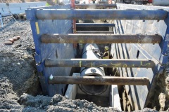 January 2022 - A worked installs underground utilities inside a trench box on U.S. 1.